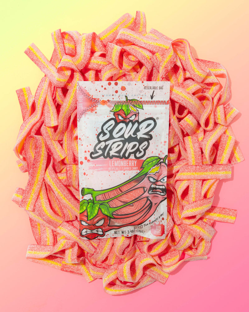 A bag of SourStrips Duos Sampler-Six Pack sits among sugar-coated pink and yellow candies on a pastel gradient background. The packaging shows cartoon sour strips with expressive faces—try these limited edition flavors!.