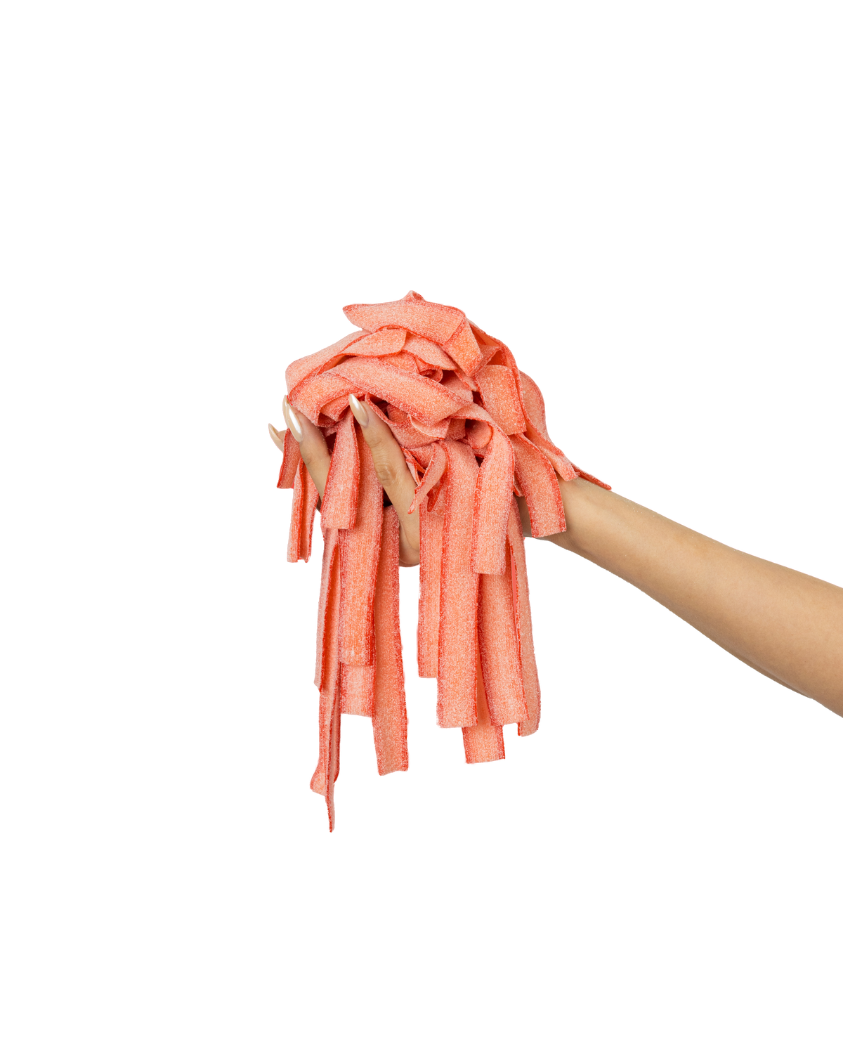 A hand with white-painted nails holding a pile of pink, textured ribbon-like material against a bright pink background.