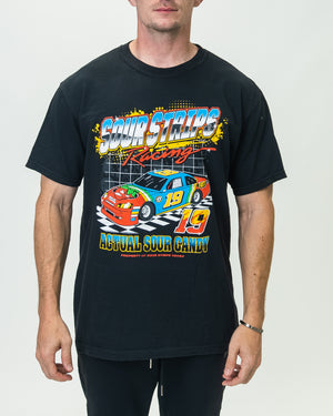 A person is wearing a black Racing Tee by SourStrips featuring a vibrant “Sour Strips Racing” graphic. The oversized box fit showcases a racing car with the number 19 and the text "Actual Sour Candy." This unisex design pops against the plain white background as they face forward.