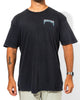 A man wearing the SourStrips Blue Venom Tee—a loose-fitting unisex cotton shirt with "SOUR STRIPS" on the chest—light-colored pants, a wristwatch, and visible arm tattoos stands against a white background.