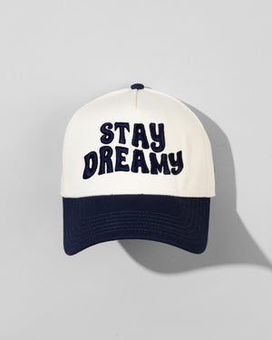 The SourStrips Dreamberry Hat-White features bold "STAY DREAMY" lettering on the front and an embroidered logo, displayed against a light gray background with the cap’s shadow visible.