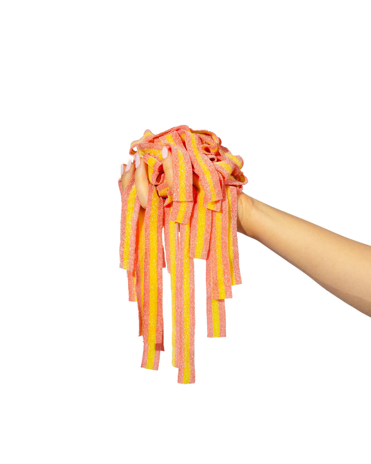 Arm sticking in from right of screen holding a mound of pink and yellow pink lemonade sour strips. The candy is dangling down from the hand and laced between the fingers.