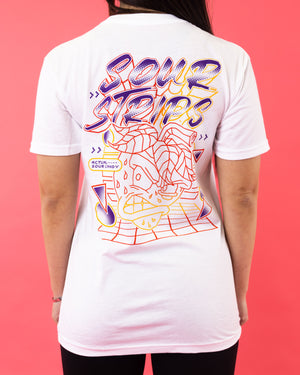 A person wearing the Digital Tee from SourStrips, a super soft graphic T-shirt made of a Polyester/Cotton blend featuring colorful text that reads "Sour Strips" in bold letters. The design includes abstract lines, geometric shapes, and an illustrated zigzagging character with an open mouth and a speech bubble that says "Actual Sour Candy.